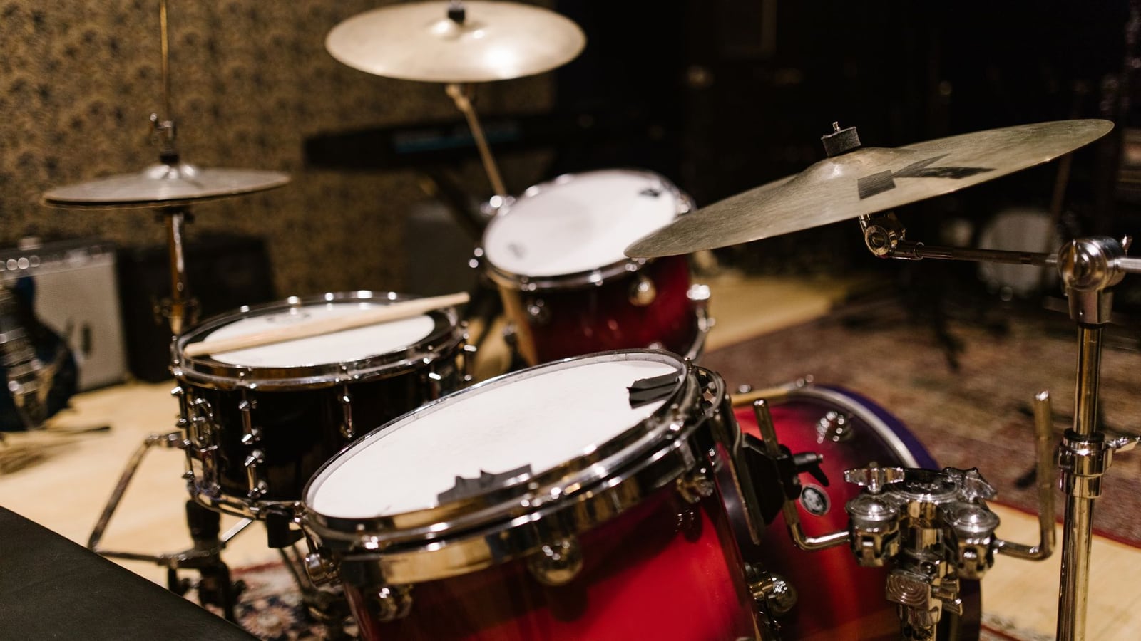 A musical band performing together in a spacious live recording room with professional microphones
