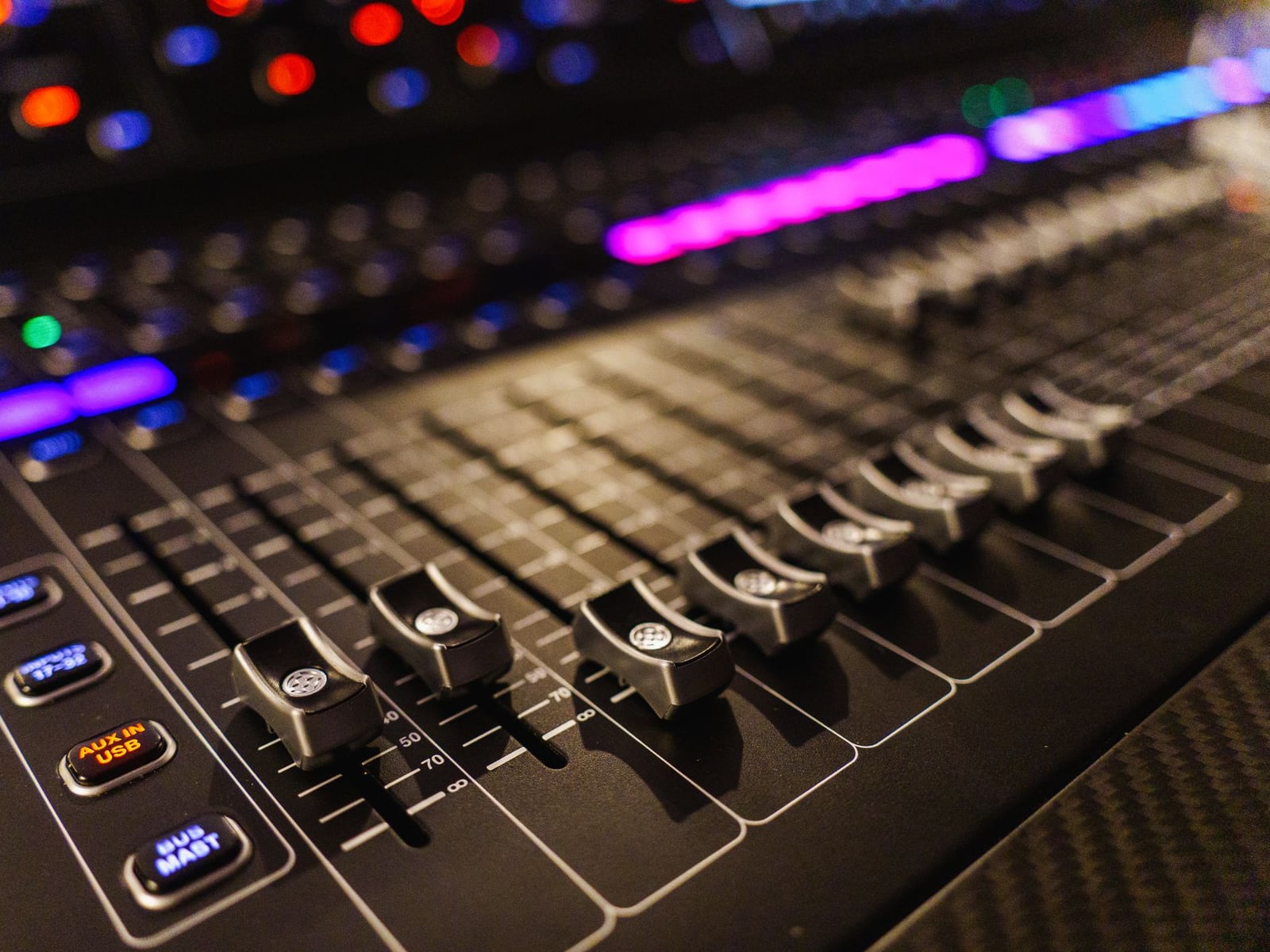 Close-up of a sound engineer adjusting levels on a professional analog mixing board